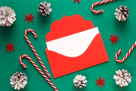 Red envelope and pine cones on green background.  Copy space for text. Letter Stock Photos