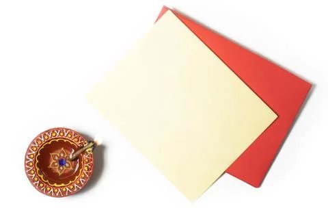 Red envelope with blank yellow paper sheets and burning clay oil lamps on w.. Stock Photos