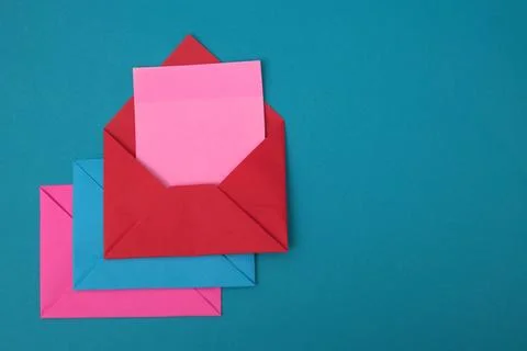 The red envelope contains empty pink sticky notes on top of a pile of blue .. Stock Photos