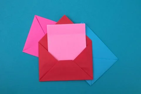 The red envelope contains empty pink sticky notes on top of a pile of blue .. Stock Photos