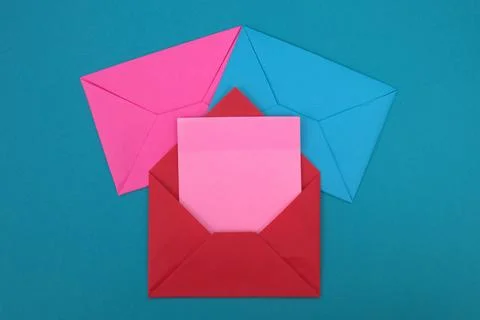 The red envelope contains empty pink sticky notes on top of a pile of blue .. Stock Photos