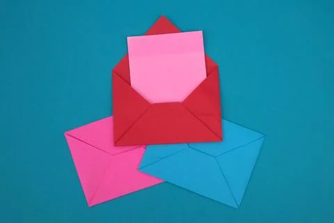 The red envelope contains empty pink sticky notes on top of a pile of blue .. Stock Photos