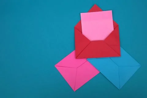 The red envelope contains empty pink sticky notes on top of a pile of blue .. Stock Photos