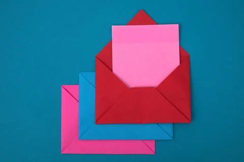 The red envelope contains empty pink sticky notes on top of a pile of blue .. Stock Photos