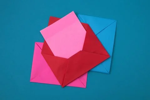 The red envelope contains empty pink sticky notes on top of a pile of blue .. Stock Photos
