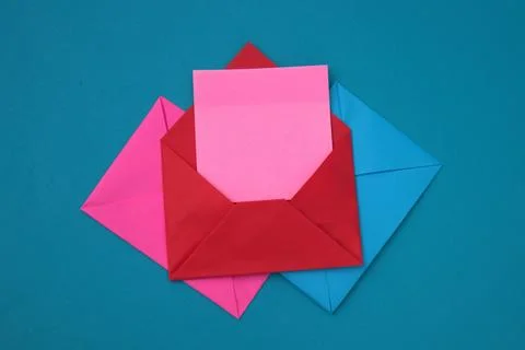 The red envelope contains empty pink sticky notes on top of a pile of blue .. Stock Photos