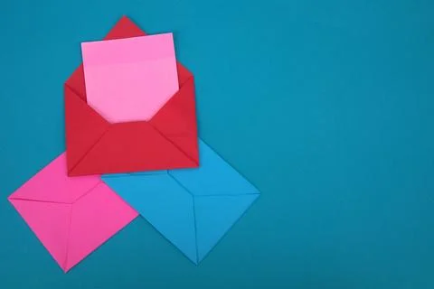The red envelope contains empty pink sticky notes on top of a pile of blue .. Stock Photos