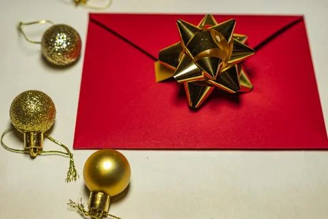 Red envelope with gold bow and Christmas baubles Stock Photos