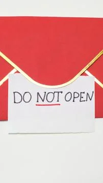 Red envelope with handwritten note stating "DO NOT OPEN" attached to it Foto stock