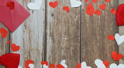 Red envelope, red and white hearts on a wooden background. Copy space. Festiv Stock Photos