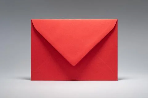 Red envelope resting on plain gray background for special occasions, greeti.. Stock Photos