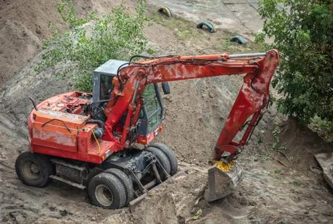 Red excavator digging a pit. Stock Photos