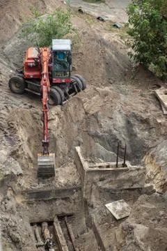 Red excavator digging a pit. Stock Photos