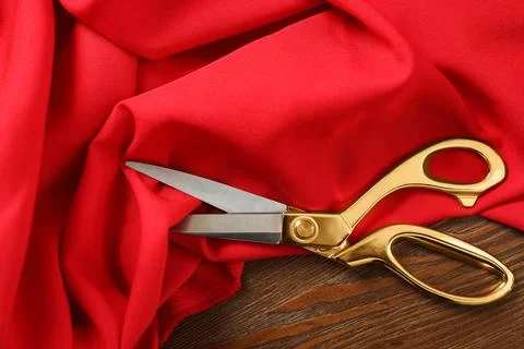 Red fabric and sharp scissors on wooden table, flat lay Stockfoto's