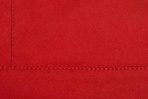 Red fabric as a background. Element of red clothing macro photo. Stock Photos