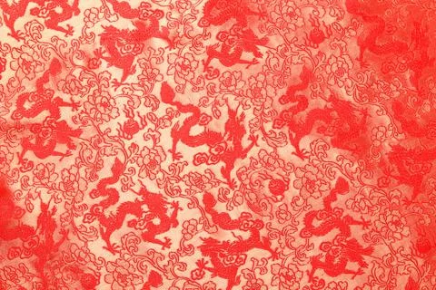 Red fabric with a dragon pattern. The concept of the Chinese New Year. Stock Photos