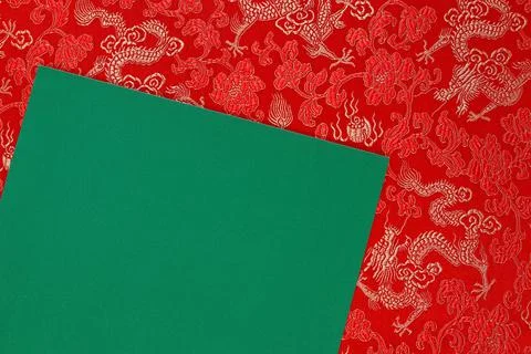 Red fabric with dragon pattern with green copy space for text. Stock Photos