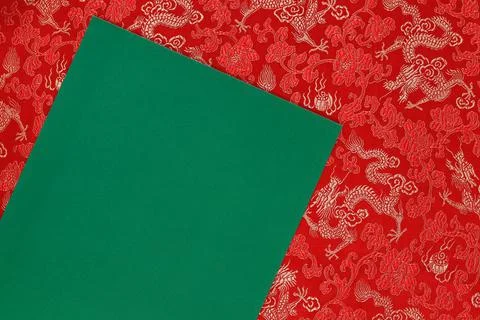 Red fabric with dragon pattern with green copy space for text. Stock Photos