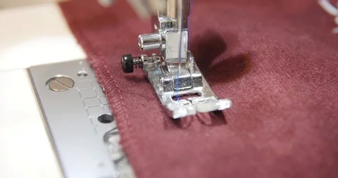 Red fabric passing through sewing machine. Stock Footage 120042770