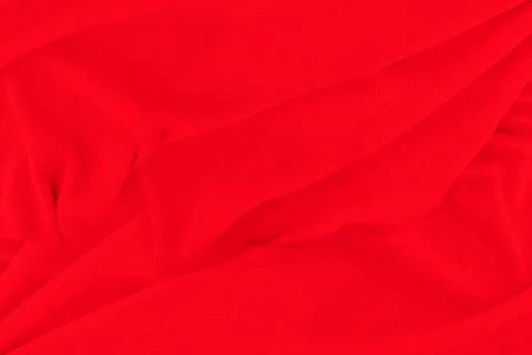 Red fabric texture background. Abstract cloth backdrop with soft waves. Stock Photos