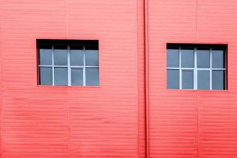 Red facade wall with two windows with reflection of sky. Copy space structure 库存照片