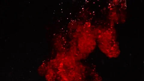 Red falling liquid into water makes many bubbles Stock Footage 75816313