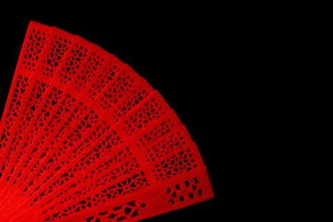Red fan with a pattern closeup. Isolate on black background Foto stock