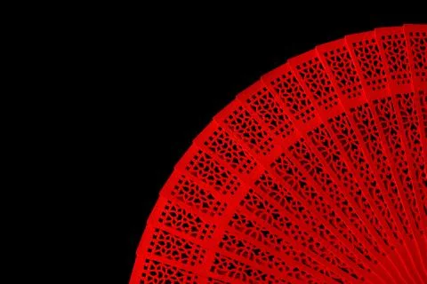 Red fan with a pattern closeup. Isolate on black background Stock Photos