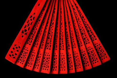 Red fan with a pattern closeup. Isolate on black background Stock Photos