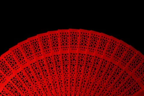 Red fan with a pattern closeup. Isolate on black background Foto stock