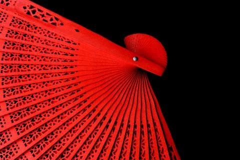 Red fan with a pattern closeup. Isolate on black background Stock Photos