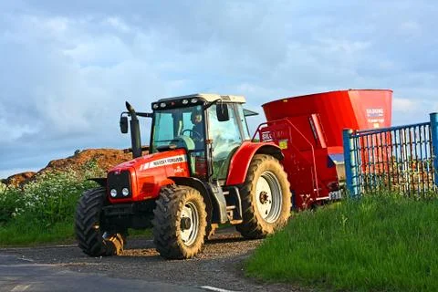 A red farm tractor during spring farm work Stock Photos