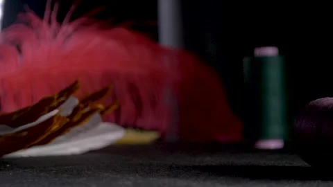 Red feather green thread roll fall dolly slow motion Stock Footage 267979454