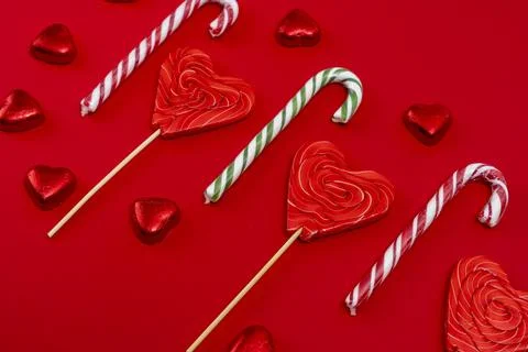 Red festive Christmas background with candy in the shape of hearts Stock Photos