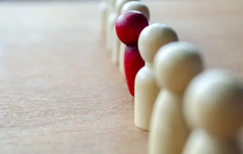 A red figurine stood up representing central focus that may reflect leaders.. Stock Photos