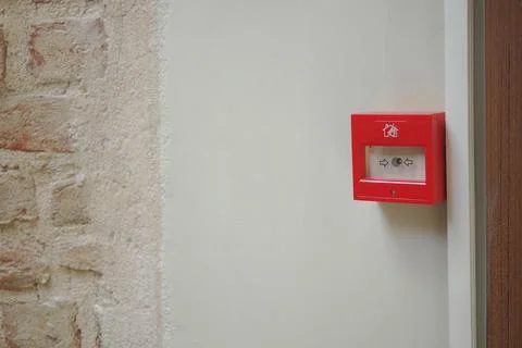Red fire alarm box mounted on a wall in a building interior Stock Photos