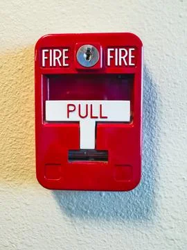 Red fire alarm box with "PULL" handle for emergencies. Stock Photos