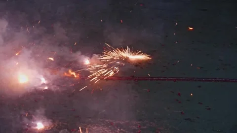 Red fire crackers are exploding or burning on the road in hyderabad, telangana Stock Footage 302525121