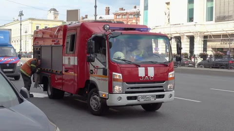 Red fire engine with flashing blue lights navigates Saint Petersburg traffi.. Vídeos de archivo 323972056