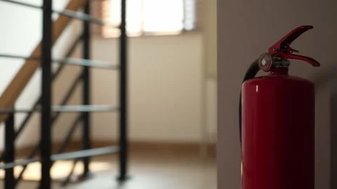 A red fire extinguisher mounted on the wall inside home, Safety for emergencies. Stock Footage 302443474