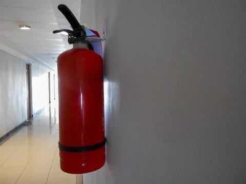 Red Fire Extinguisher Mounted on Wall in Building Corridor Photos