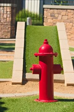 Red fire hydrant beside artificial turf Stock Photos