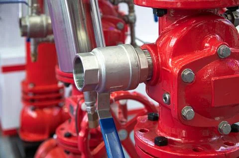 A red fire hydrant with a blue ball valve Stock Photos