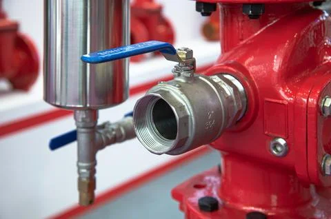 A red fire hydrant with a blue ball valve Stock Photos