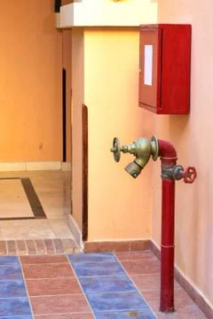 Red fire hydrant in the building. Stock Photos
