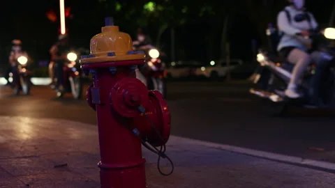 Red fire hydrant on a busy city street at night Video stock 336099490