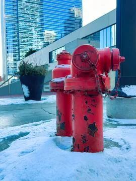 Red fire hydrant on city sidewalk with buildings in background Stock Photos