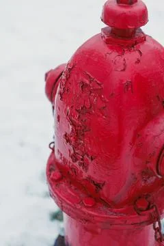 Red fire hydrant covered in snow stands on the street during winter near a .. 库存照片