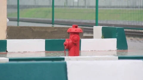 A red fire hydrant in the pouring rain Stock Footage 75893840