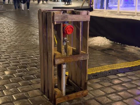 Red fire hydrant securely protected inside a rustic wooden crate, represent.. Stock Photos